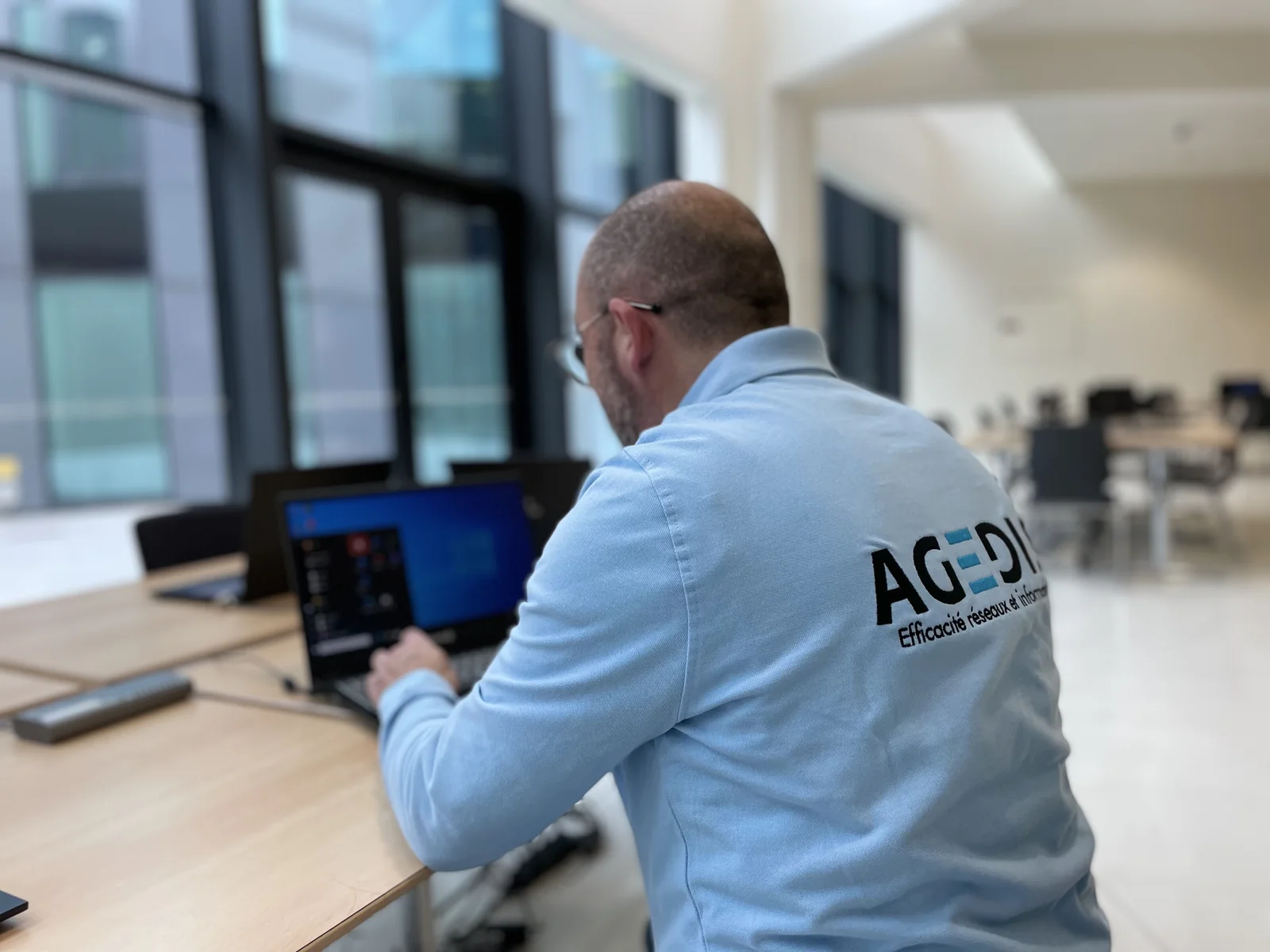 Intervenant Agedis devant un poste de travail. Photographie d’archives de l’équipe.